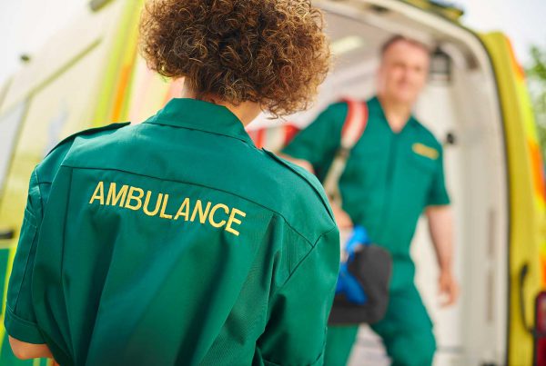 paramedic with back to viewer in front of ambulance