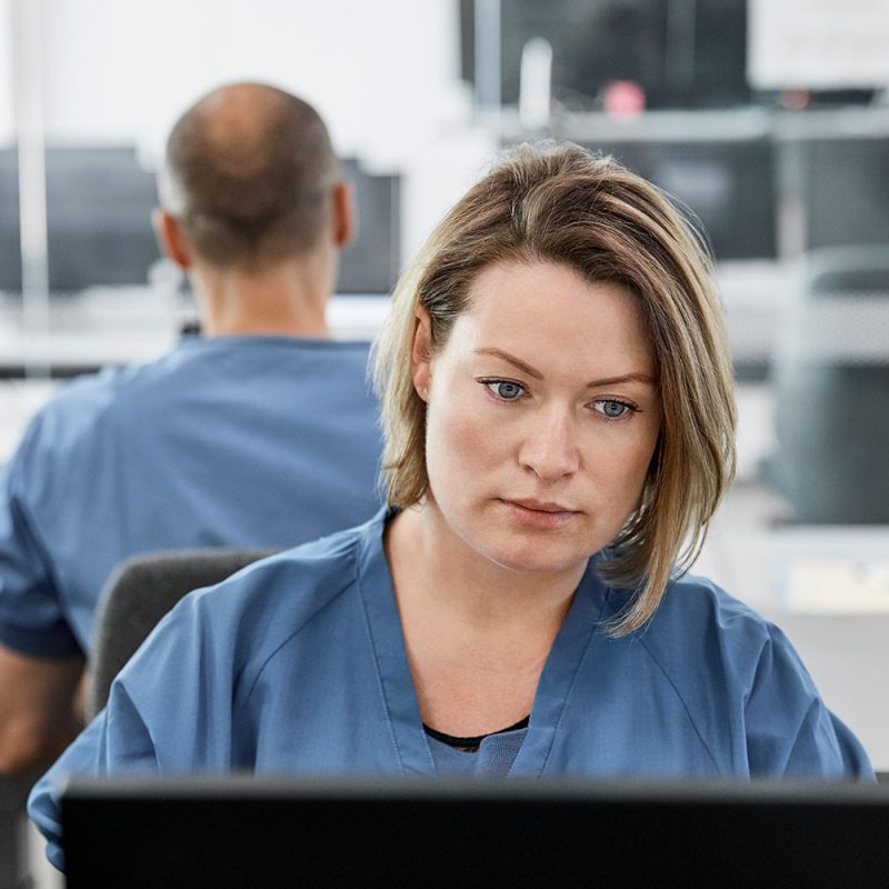 Medical staff facing the viewer looking at computer screen