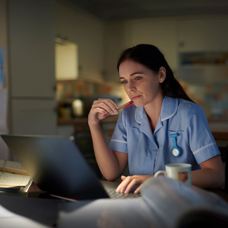 clinician at a computer late at night