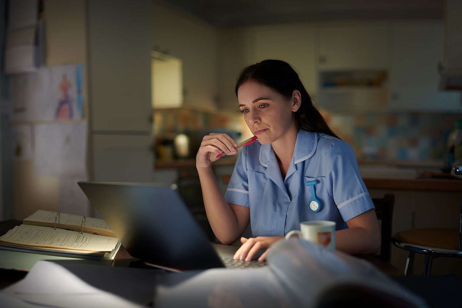 clinician at a computer late at night